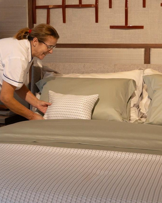 A housekeeper making up the bed in a Laxmi-managed home